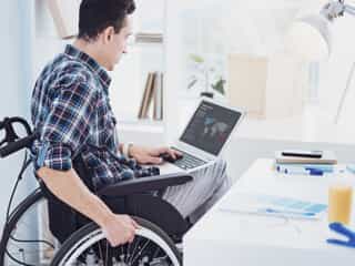 man in wheelchair on laptop